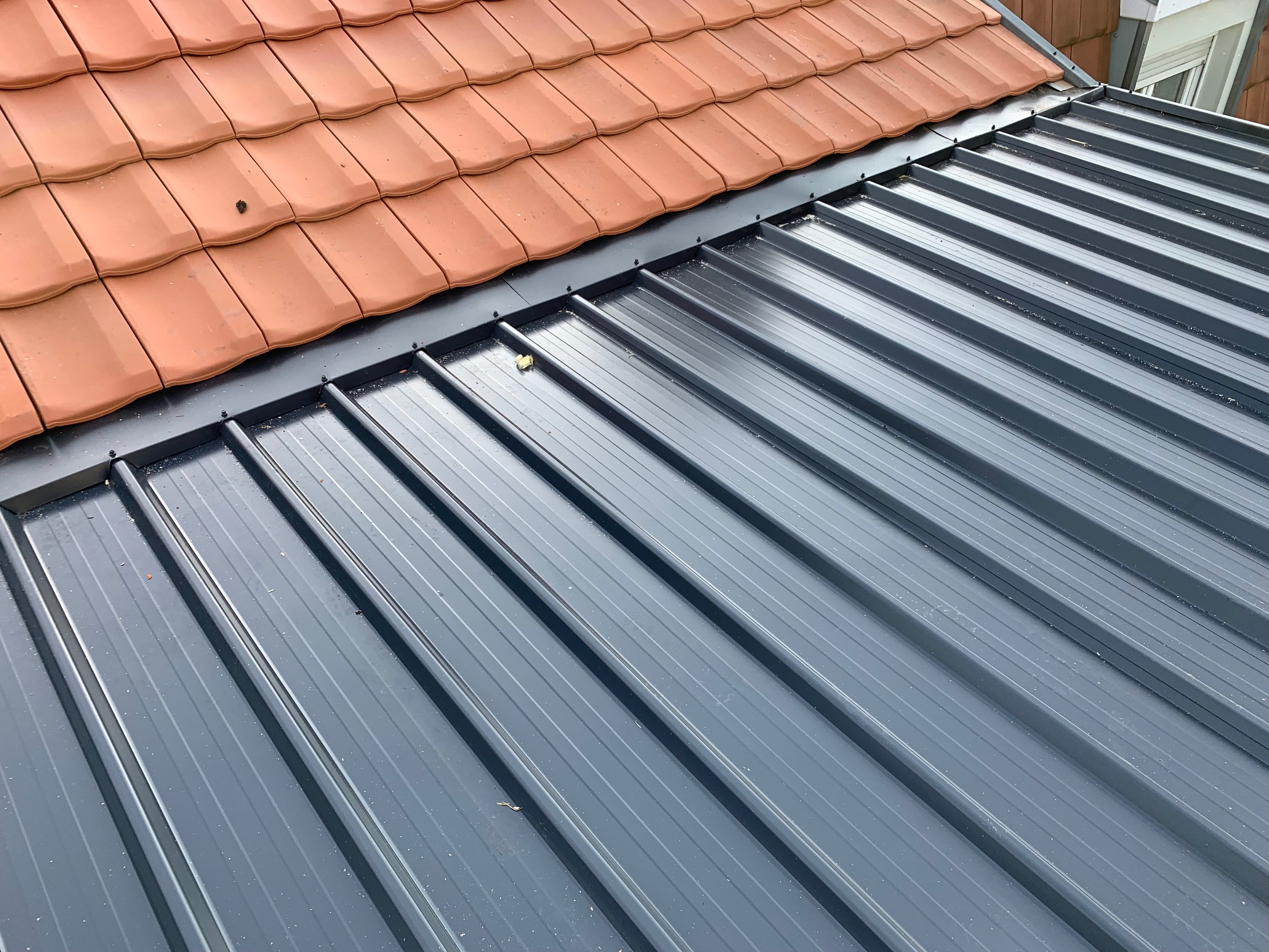 Raccord bac acier et tuiles sur toiture rénovée